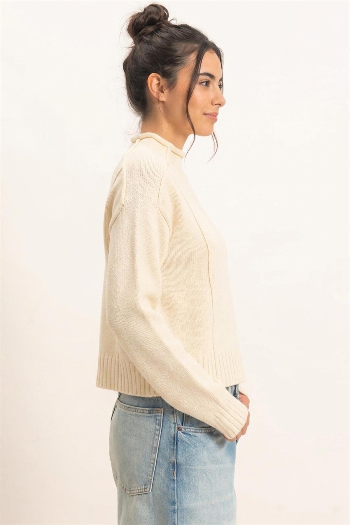 Remy Roll Neck Reversed Seam Sweater in Cream — close-up of reversed seam detail and ribbed cuffs