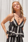 Woman wearing a black and white patterned dress against a white background