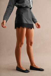 Luxe Faux Leather Lace Trim Mini Skort in Black — side view showing high-waisted fit and lace trim hem