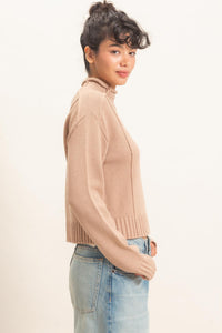 Remy Roll Neck Reversed Seam Sweater in Taupe — back view on model showing reversed seam detailing