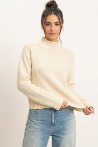 Remy Roll Neck Reversed Seam Sweater in Cream — back view on model showing reversed seam detailing